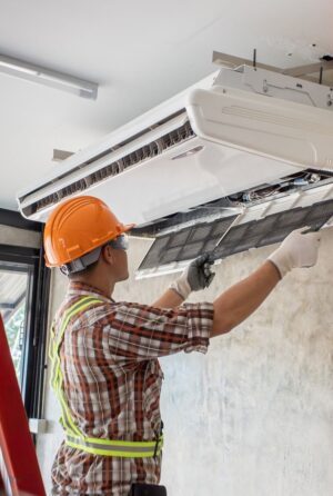 Installation d'une pompe à chaleur à l'intérieur d'une maison par un technicien de PC Rénovation