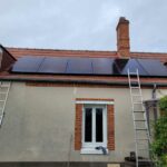 Installation de panneaux photovoltaïques par PC Rénovation sur le toit d'une maison individuelle avec cheminée