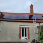Installation de panneaux photovoltaïques par PC Rénovation sur le toit d'une maison individuelle avec cheminée