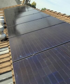 Installation de panneaux photovoltaïques par PC Rénovation sur le toit d'une maison avec des tuiles