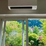 pompe à chaleur air-air installée par PC Rénovation au dessus d'une baie avec vue sur le jardin