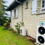 pompe à chaleur air-air installée par PC Rénovation vue extérieure devant un rosier dans le jardin